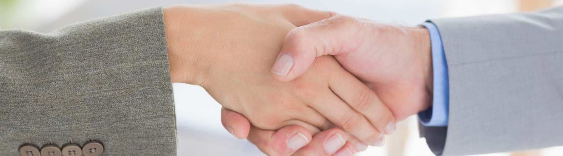 four people each holding a large puzzle piece towards each other